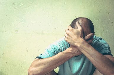 Man with Hands Over Face