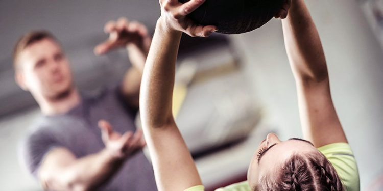 trainer teaching a client how to design a weight loss program