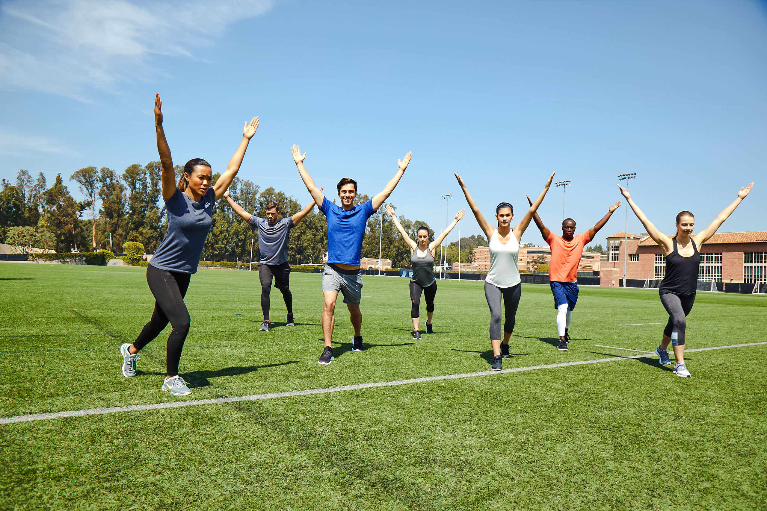 Group workout class doing exercise outdoors