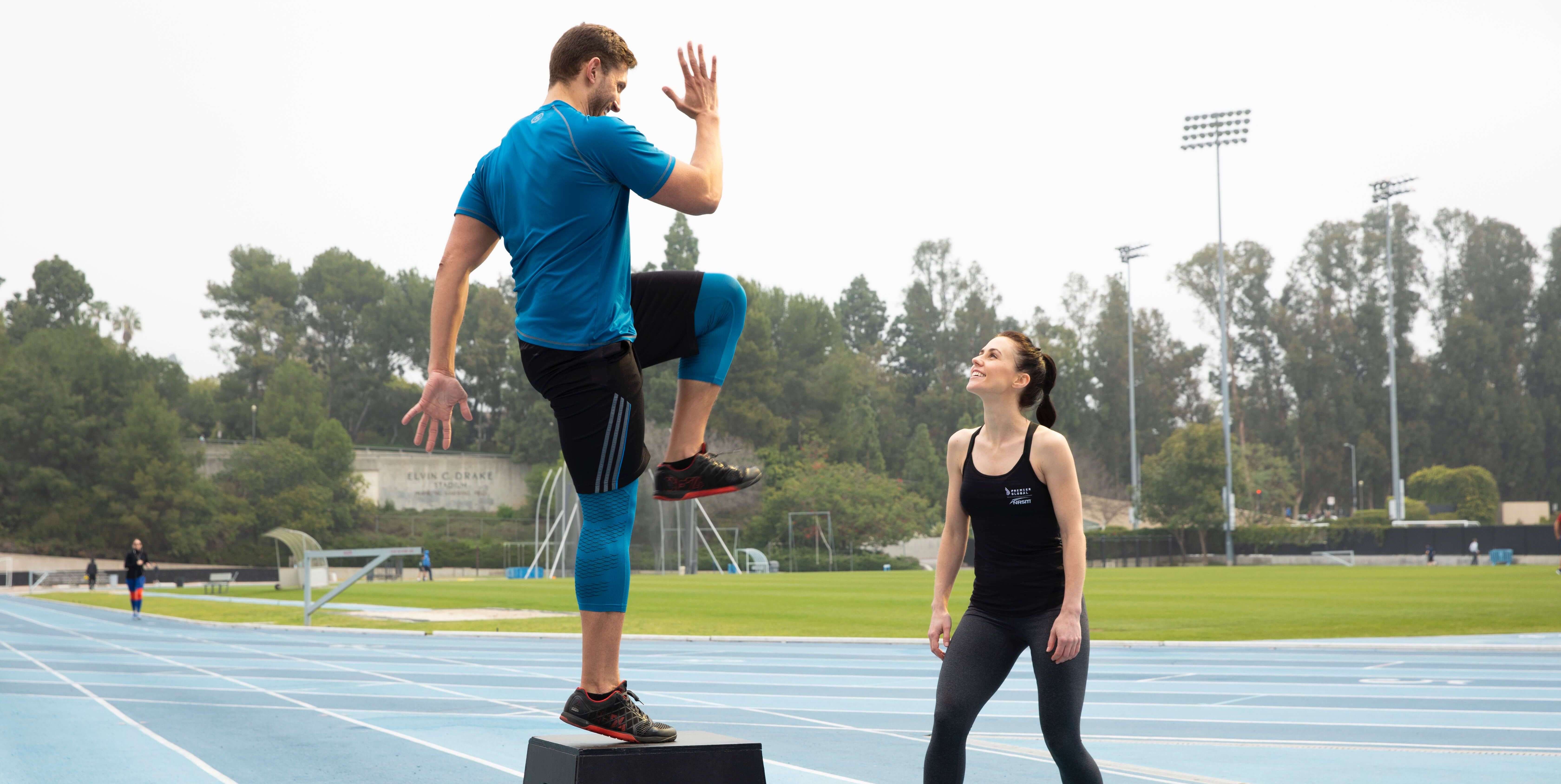 Personal trainer working with client outdoors