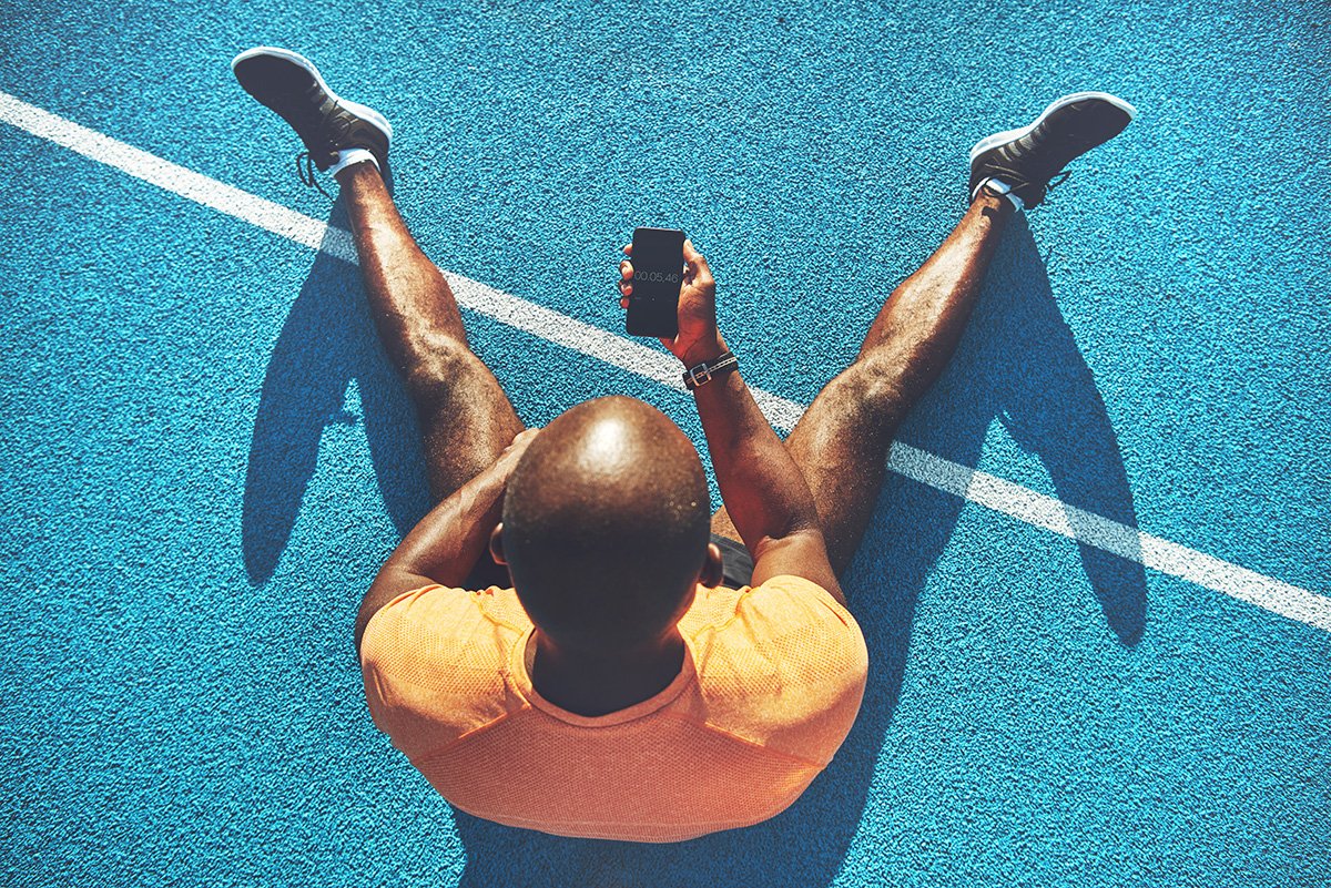 trainer sitting on ground looking at phone