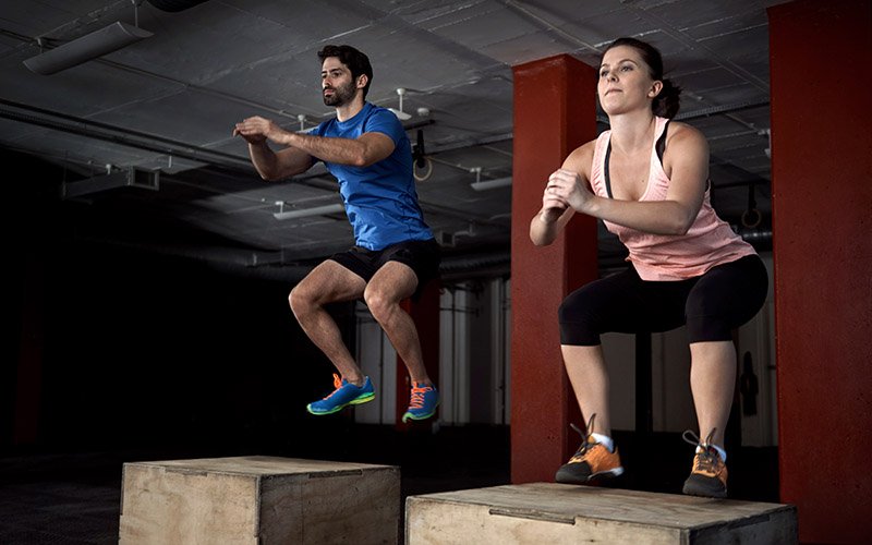 two athletes doing plyometric box jumps